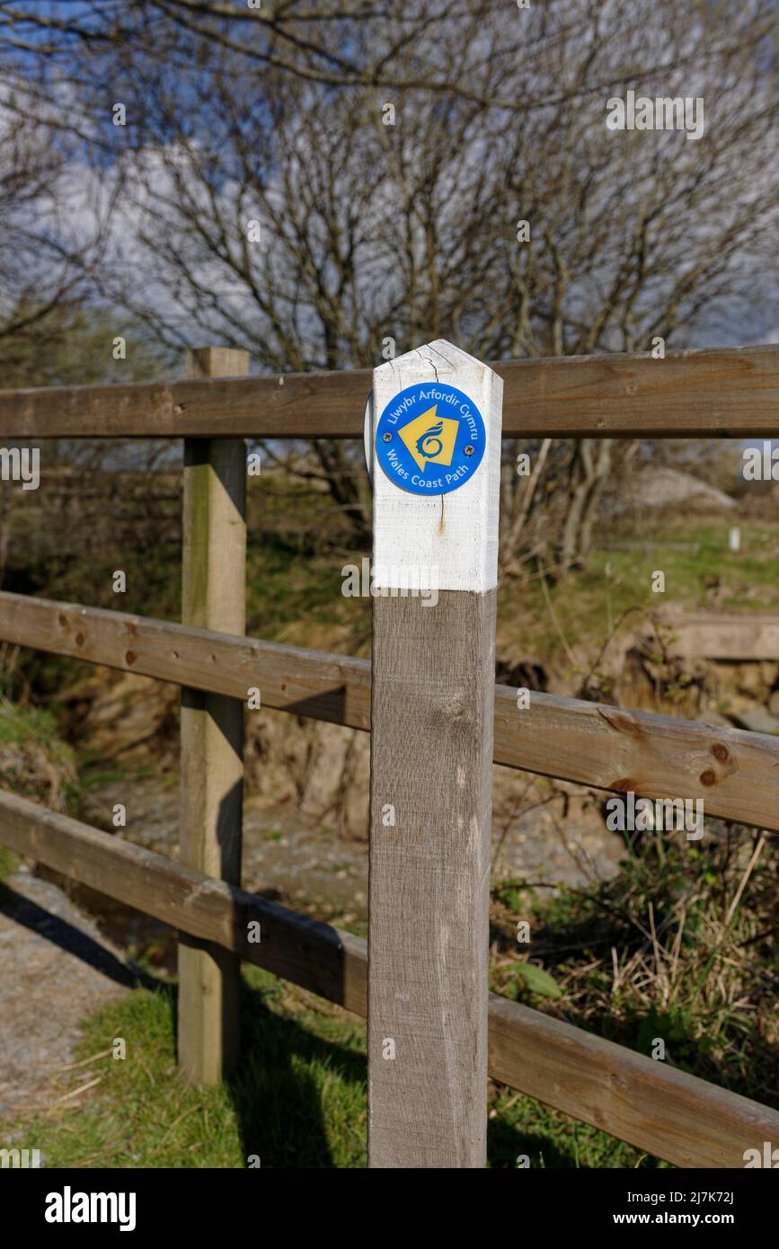 Panneau de signalisation de chemin de la côte gallois et anglais du pays de galles en bois bilingue, droit de passage public, avec clôture en bois en arrière-plan dans la campagne du nord du pays de galles au royaume-uni Banque D'Images