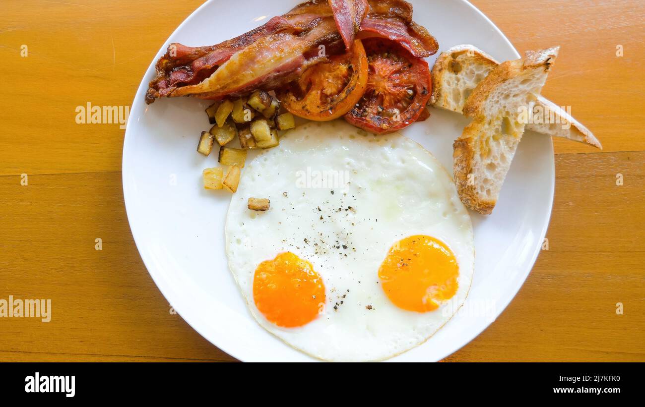 Petit-déjeuner américain avec œufs frais sur une table en bois au restaurant Banque D'Images