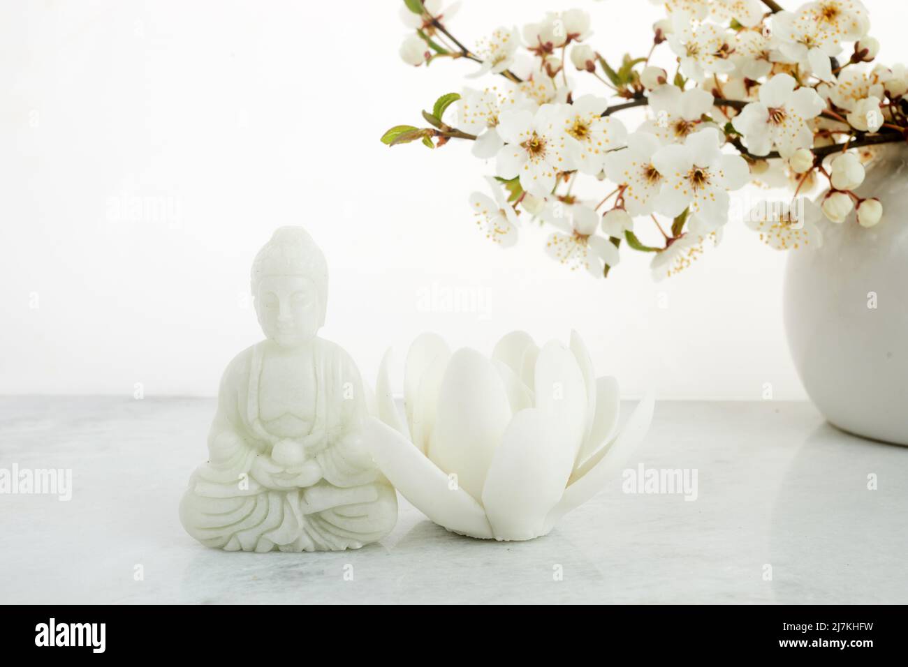 Vesak, Wesak, anniversaire de Bouddha. Statue de Bouddha avec cerisier fleuri sur fond blanc. Rituel spa. Santé mentale et méditation. Banque D'Images