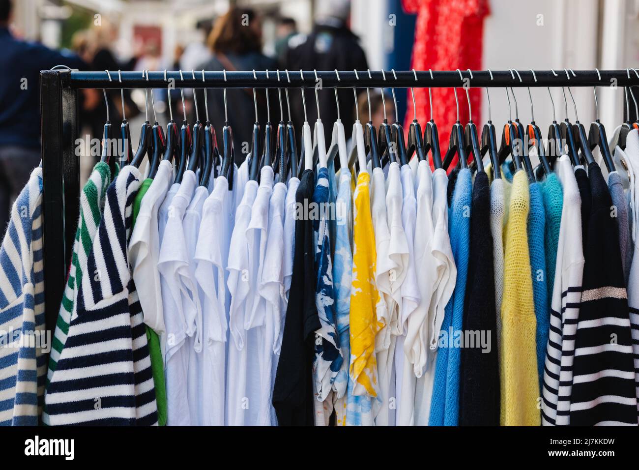 Porte-vêtements en métal avec divers t-shirts et chandails sur des cintres placés dans une boutique de mode moderne Banque D'Images Porte-vêtements en métal avec divers t-shirts et chandails sur des cintres placés dans une boutique de mode moderne Banque D'Images