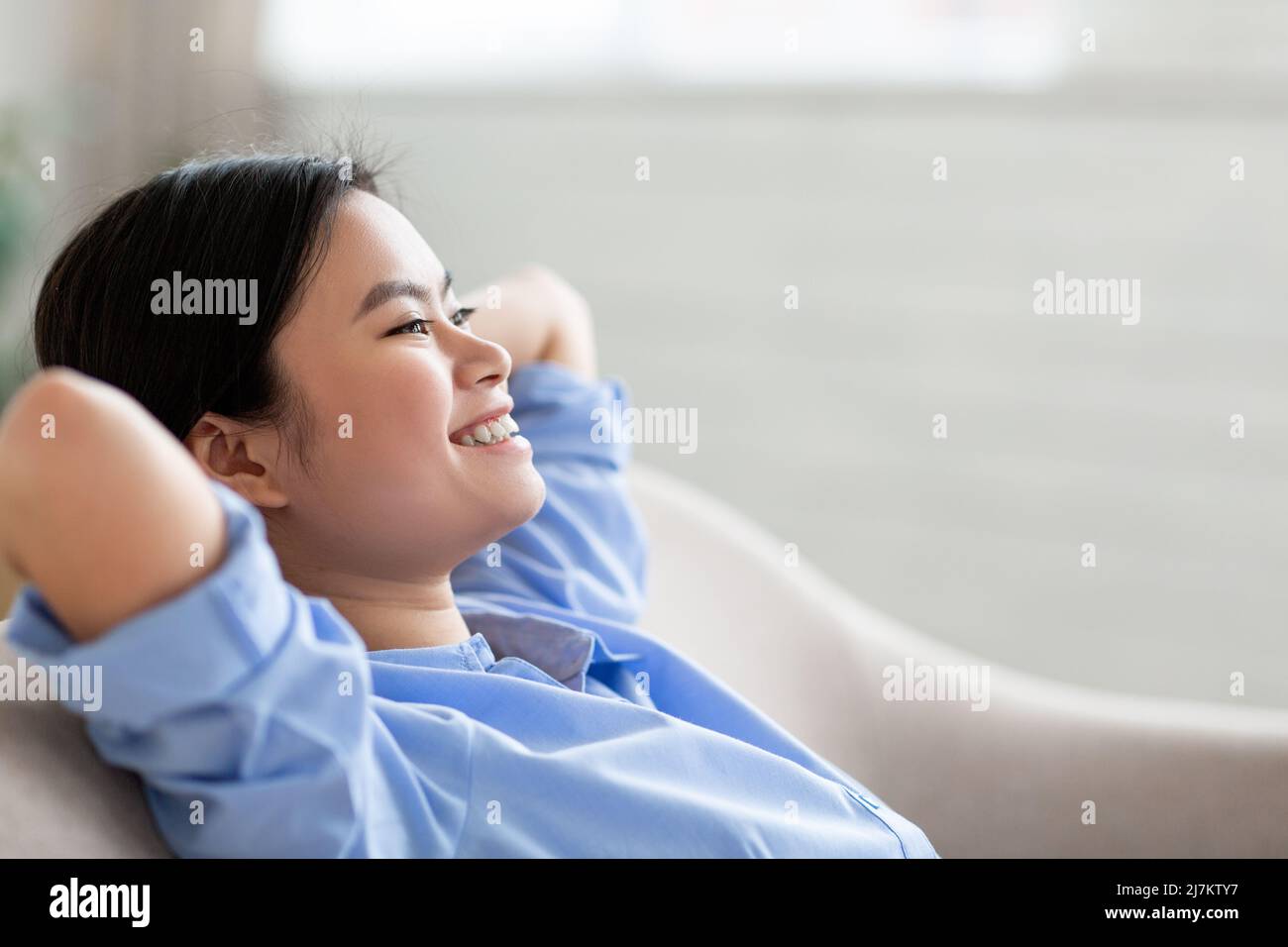 Jeune femme asiatique joyeuse appréciant le week-end à la maison Banque D'Images