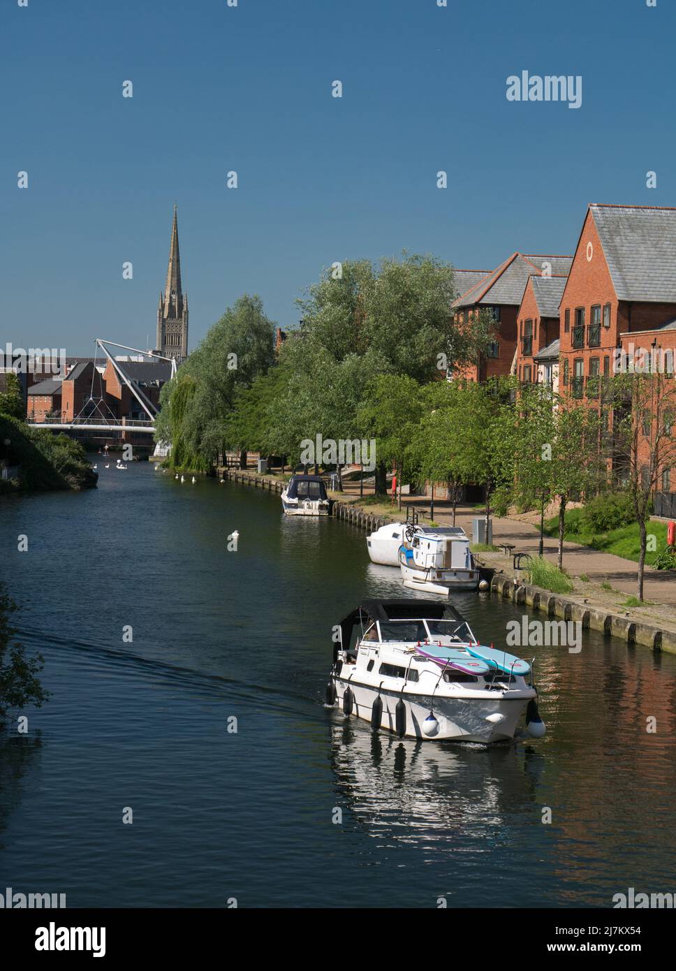 La rivière Wensum dans la ville de Norwich, qui fait partie des Norfolk Broads, avec un nouveau développement et la cathédrale Spire, Norwich, Norfolk, Angleterre, Royaume-Uni Banque D'Images