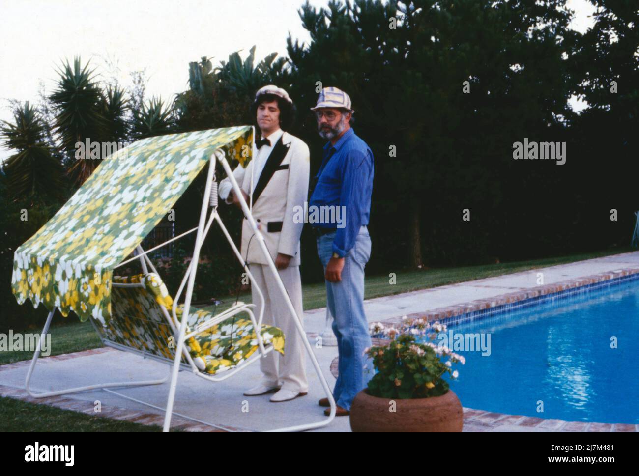 Hollywood, ich komme, deutscher Fernsehfilm, Deutschland, 1980, im Bild: Ilja Richter und Regisseur Ralf Gregan während der Dreharbeiten in ZSA Gabor's Villa in Beverly Hills, hier am Swimmingpool. Hollywood, ich komme, film TV allemand, Allemagne, 1980, Ilja Richter et le réalisateur Ralf Gregan pendant le tournage à la villa de ZSA ZSA Gabor à Beverly Hills, ici à la piscine. Banque D'Images