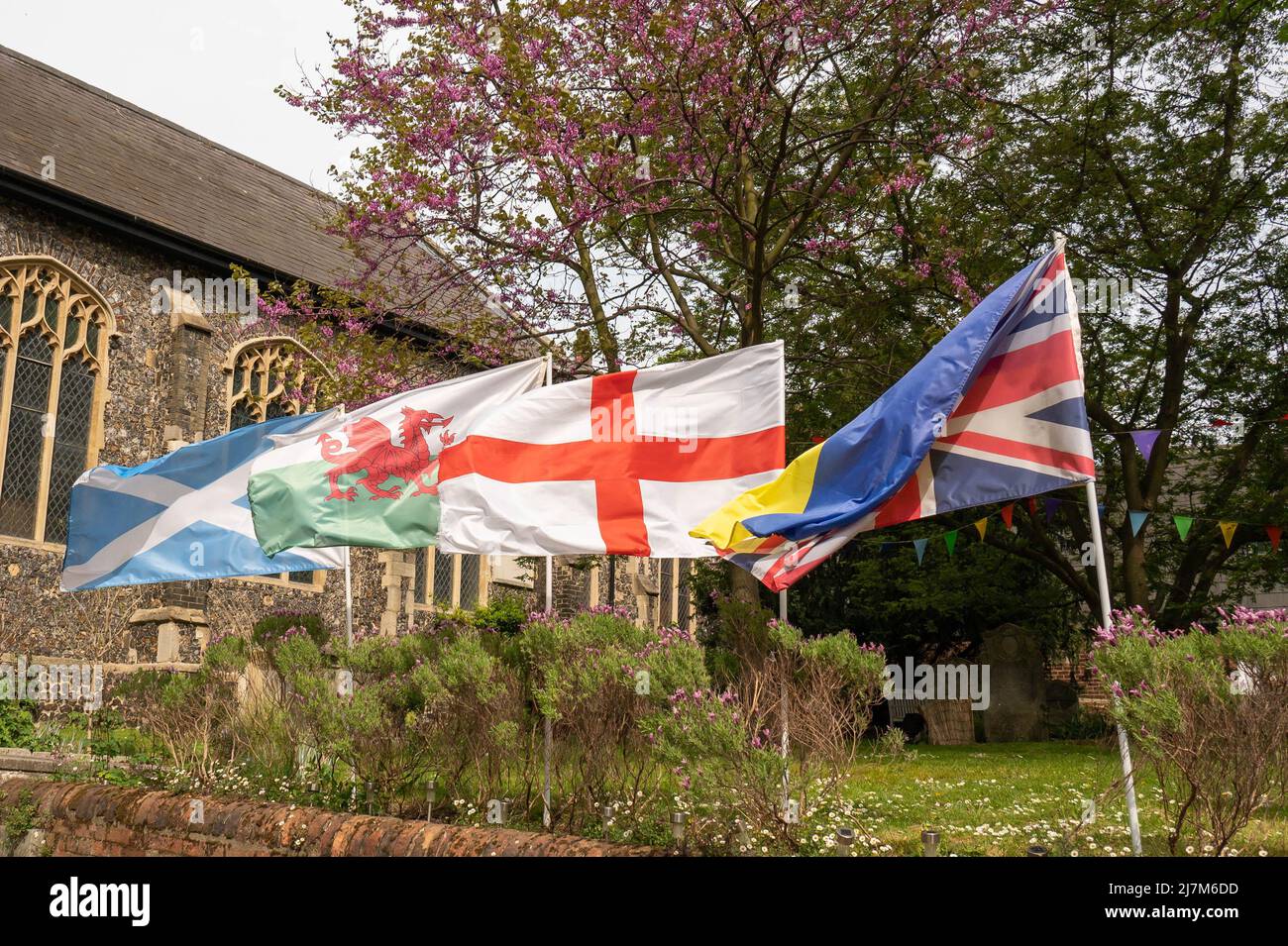 Les drapeaux de l'Angleterre, de l'Écosse, du pays de Galles et de l'Union Jack agitant dans le vent à une église dans la ville de Norwich Banque D'Images