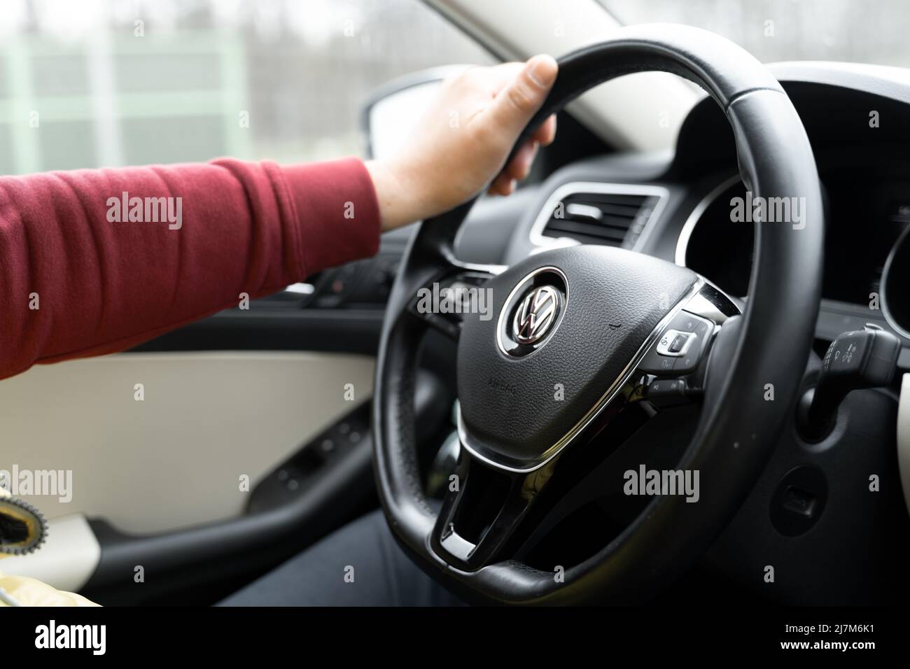 Poznan, Pologne - 20 avril 2022 Homme buvant une voiture Volkswagen. Roue en cuir et main d'homme sur elle. Banque D'Images