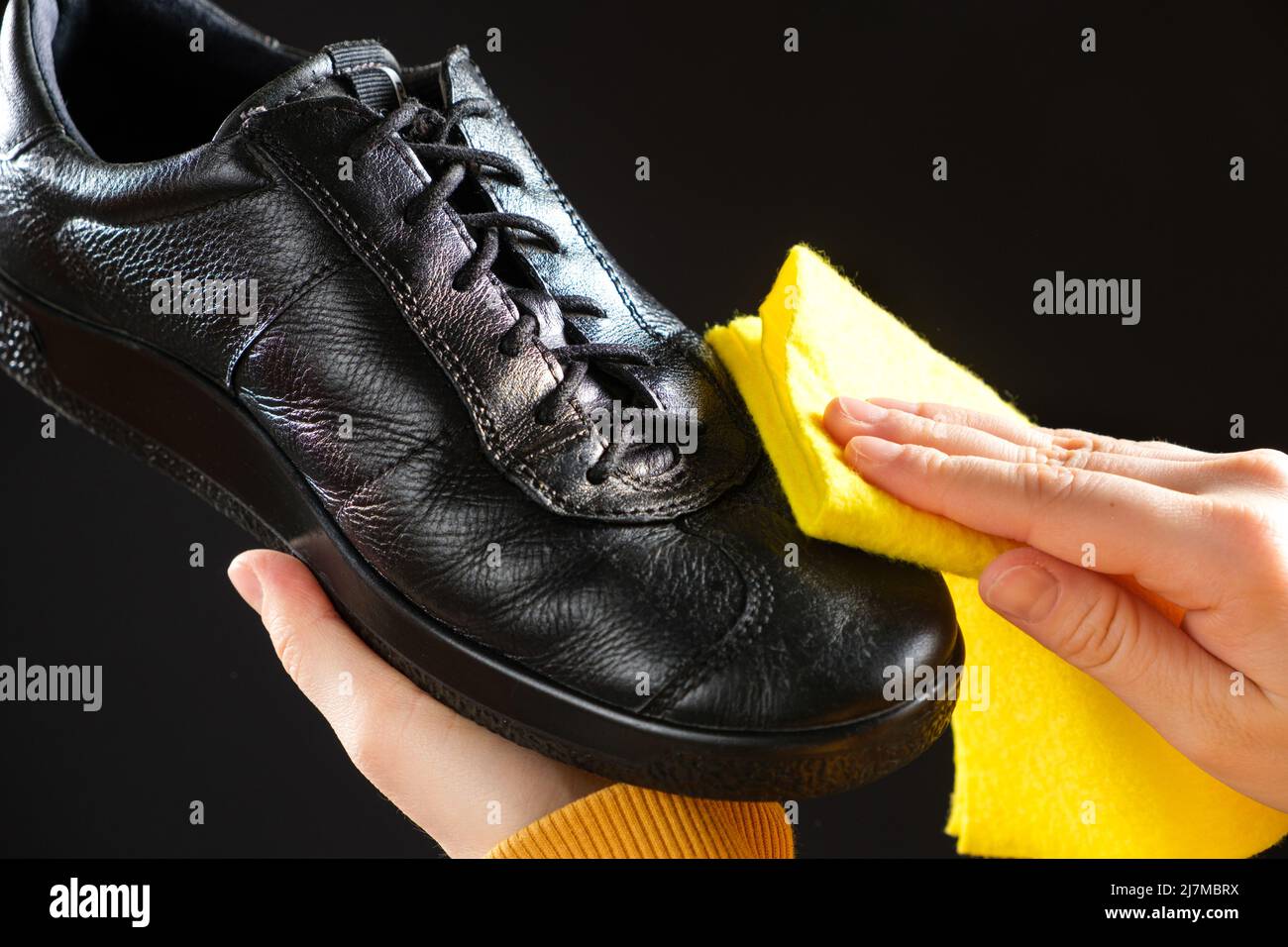 Un homme essuie les chaussures noires en cuir pour hommes avec un chiffon à  chaussures jaune. Nettoyage de la poussière, entretien des chaussures Photo  Stock - Alamy