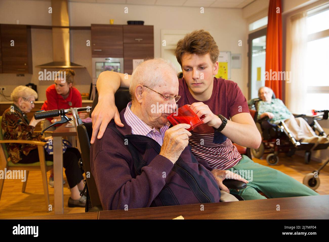 Pays-Bas, Gendt - petit-fils aide son grand-père avec son café. Ils sont dans une maison de soins infirmiers sur la section fermée pour les personnes âgées souffrant de démence. Banque D'Images