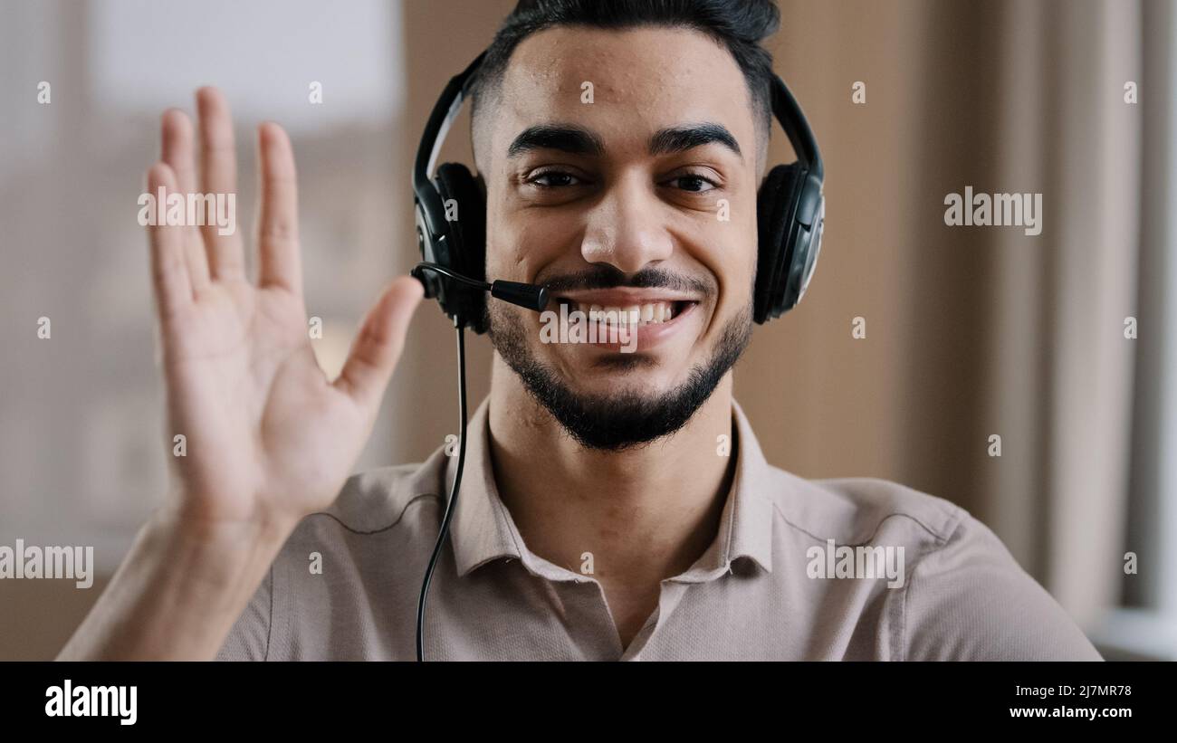 Homme souriant opérateur hispanique homme d'affaires assistance clientèle assistant de service salutation parler à la webcam porter un casque avec microphone Banque D'Images