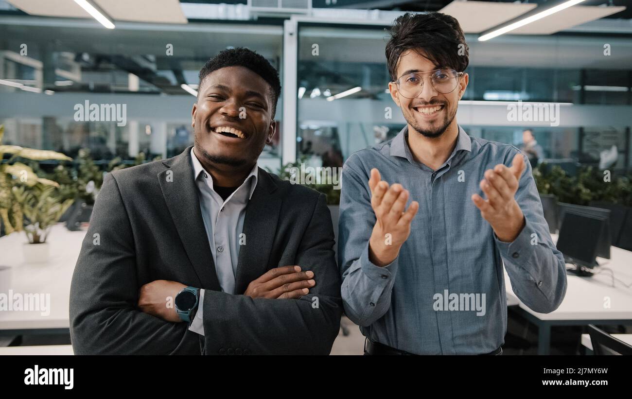 Deux collègues joyeux Africain homme arabe vendeur regardant la caméra riant blague drôle de situation d'entreprise a coulé dans l'espace de travail Banque D'Images