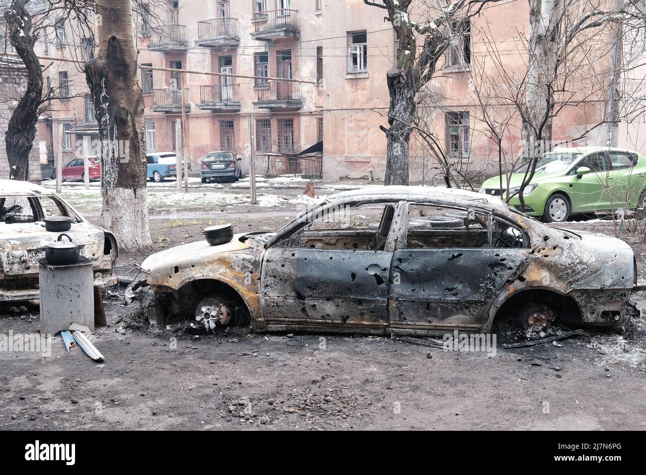 MARIOUPOL, UKRAINE - 5 mars 2022 : guerre de la Russie contre l'Ukraine. Voitures civiles du bâtiment résidentiel endommagées par des bombes ennemies Banque D'Images