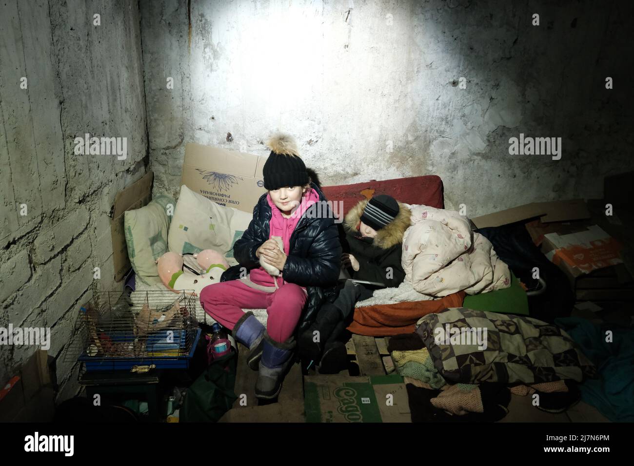 MARIOUPOL, UKRAINE - 5 MARS 2022 : un enfant ukrainien se fait abriter dans son sous-sol lors des bombardements par des bombes russes Banque D'Images
