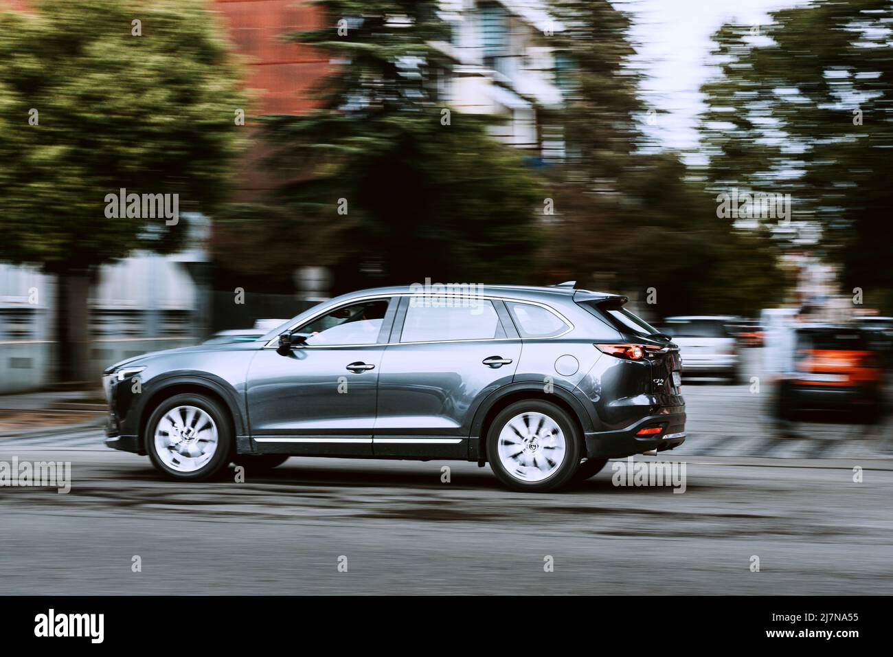 Voiture Mazda CX-9 grise 2016 en mouvement rapide dans la rue. Vus multisegment de taille moyenne sur fond flou. Banque D'Images