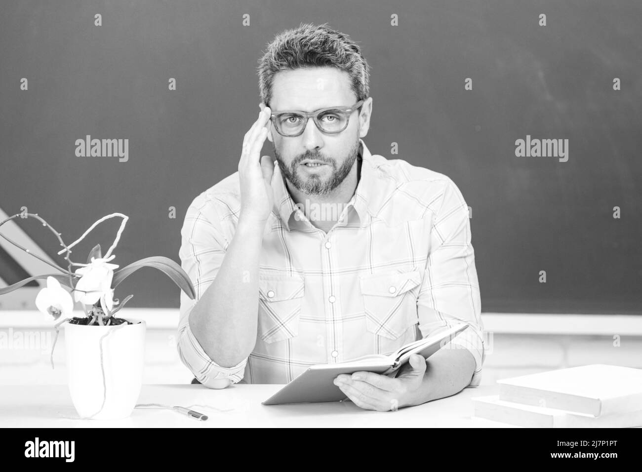 Journée des enseignants.Portrait d'un professeur ou d'un professeur tuteur mature travaillant à la table à l'université ou au lycée. Banque D'Images Journée des enseignants.Portrait d'un professeur ou d'un professeur tuteur mature travaillant à la table à l'université ou au lycée. Banque D'Images