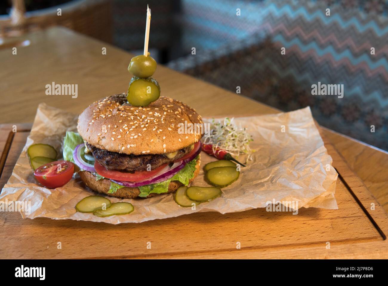 Un hamburger avec veau, feuilles de laitue, tomates et cornichons Banque D'Images