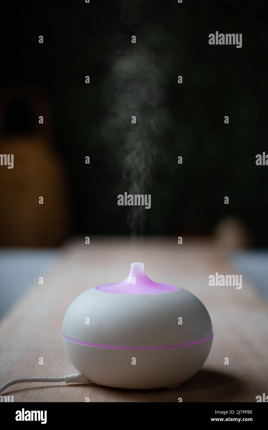 diffuseur d'huile essentiel. appareil d'aromathérapie électrique. vapeur sur fond noir Banque D'Images