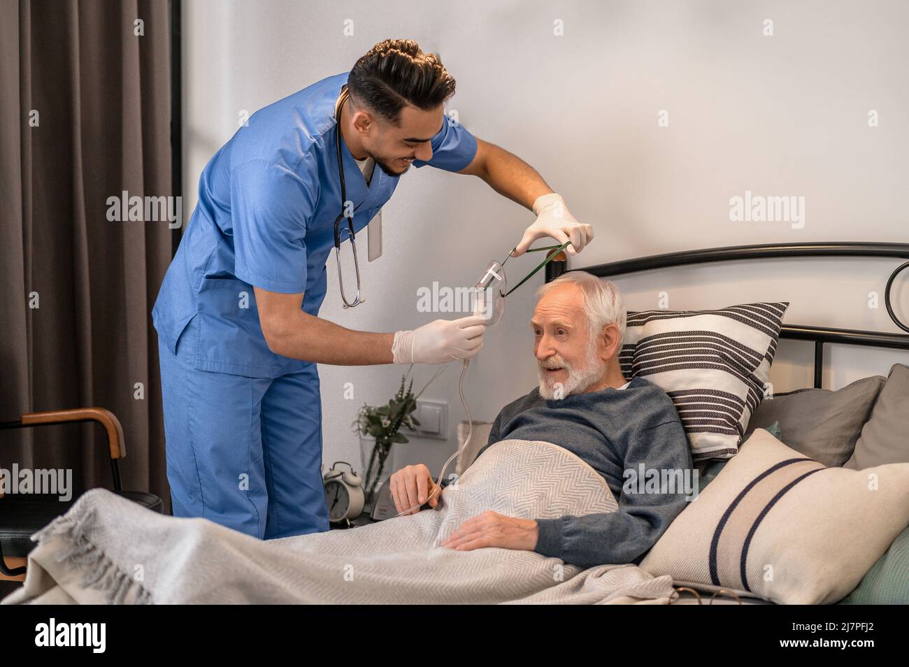 Professionnel de la santé préparant un patient âgé pour une intervention médicale Banque D'Images