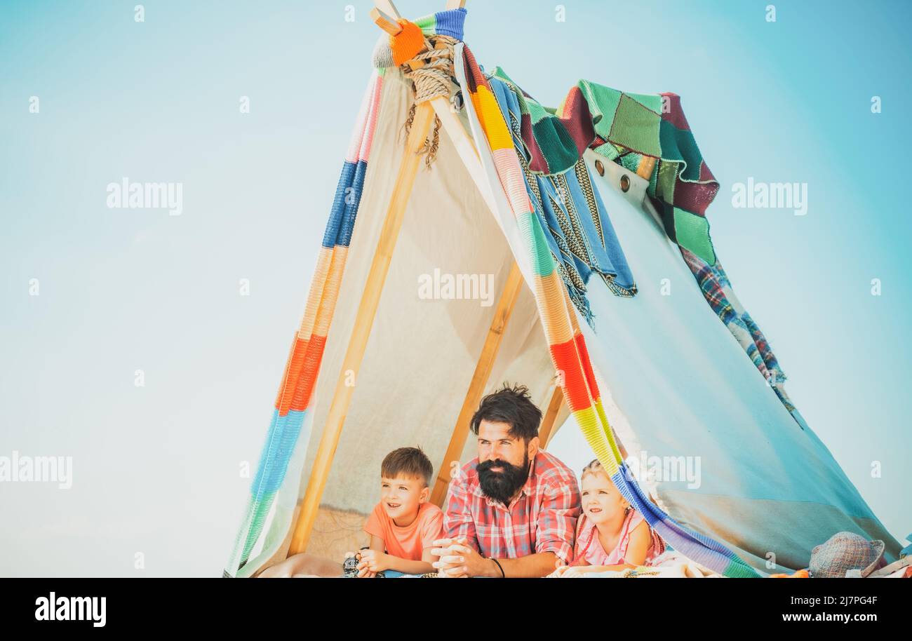 Papa avec les enfants jouant ensemble dans la tente. En été, à l'extérieur. Famille jouant ensemble. Père heureux avec chidren, camping. Fête des pères. Concept de vacances. Banque D'Images