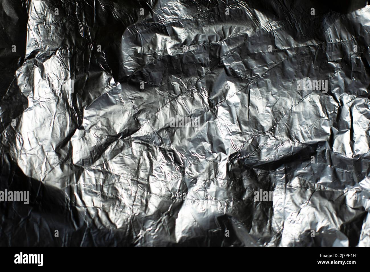 Texture de la feuille. Film froissé de couleur nervurée. Arrière-plan une surface inégale reflète la lumière. Banque D'Images
