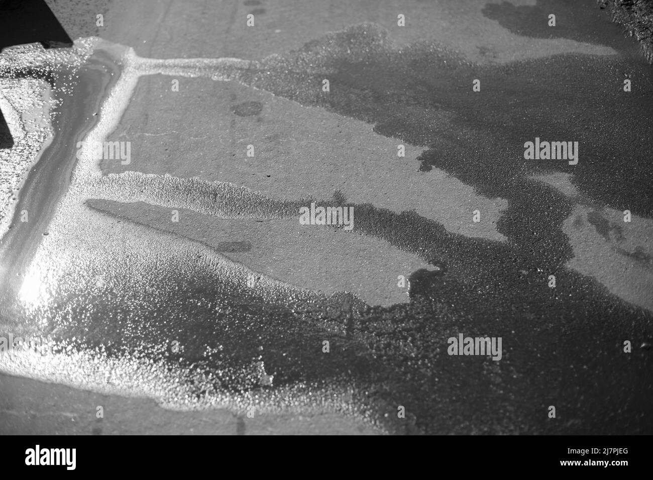 Bas de porte sur la route. Eau sur asphalte. Surface humide. Banque D'Images