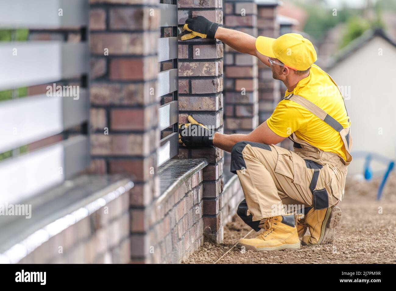 Entrepreneur de construction caucasien dans son bâtiment de clôture résidentielle en finition en 40s. Banque D'Images