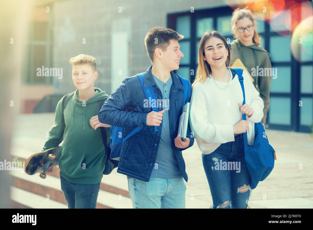 Des adolescents souriants qui marchent dehors après les leçons Banque D'Images