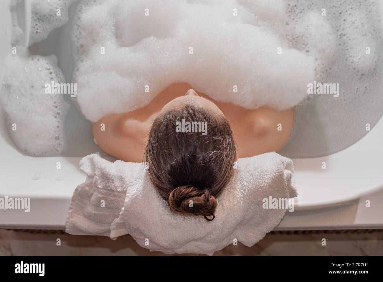 Femme se détendant dans le bain à remous avec de la mousse de savon Banque D'Images