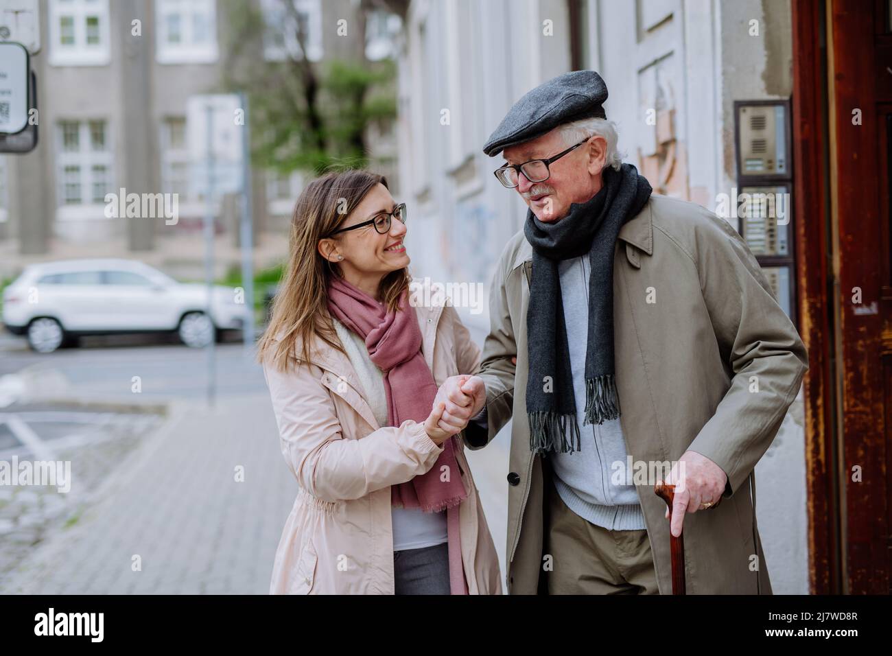 Fille adulte qui prend son homme aîné pour une promenade en ville. Banque D'Images