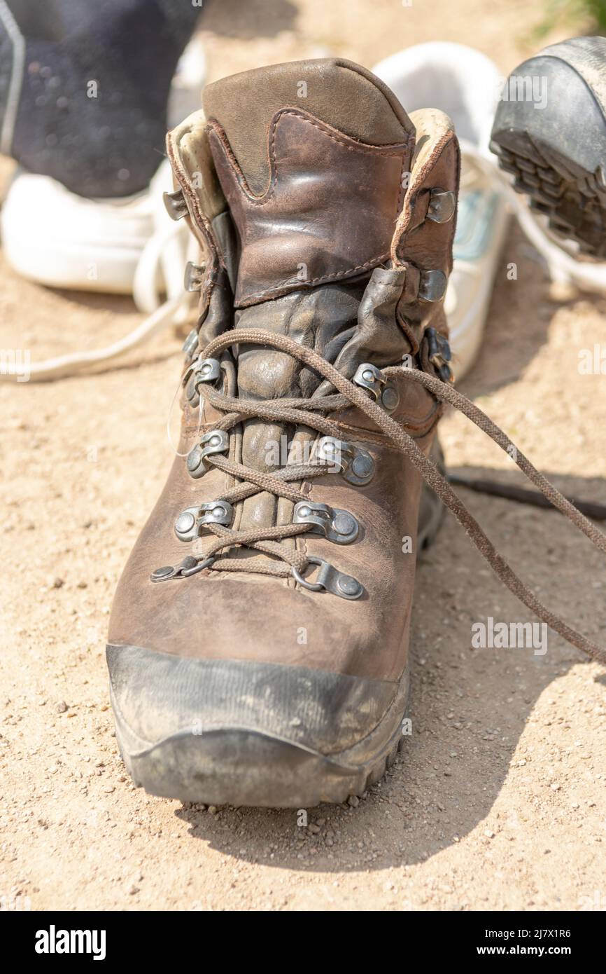 Gros plan marron chaussure de randonnée debout au soleil, normale chaussures  à l'arrière-plan, femme changeant ses chaussures Photo Stock - Alamy