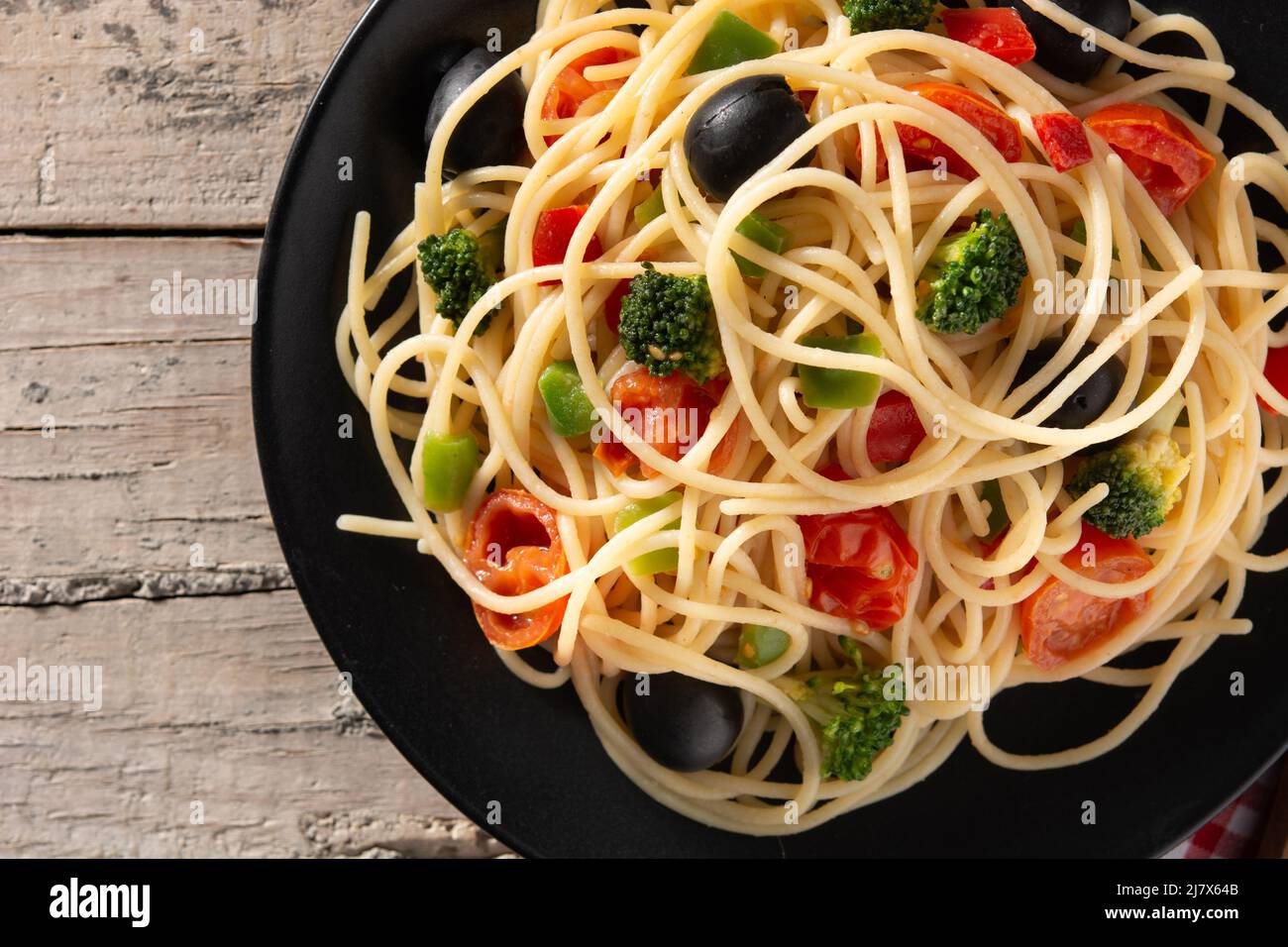 Spaghetti aux légumes (brocoli, tomates, poivrons) sur table en bois Banque D'Images