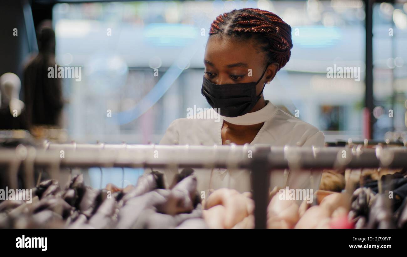Afro american femme acheteur african girl consommateur femelle shopper en noir masque médical dans le magasin de vêtements appréciant la vente rabais boutique shopping centre commercial Banque D'Images