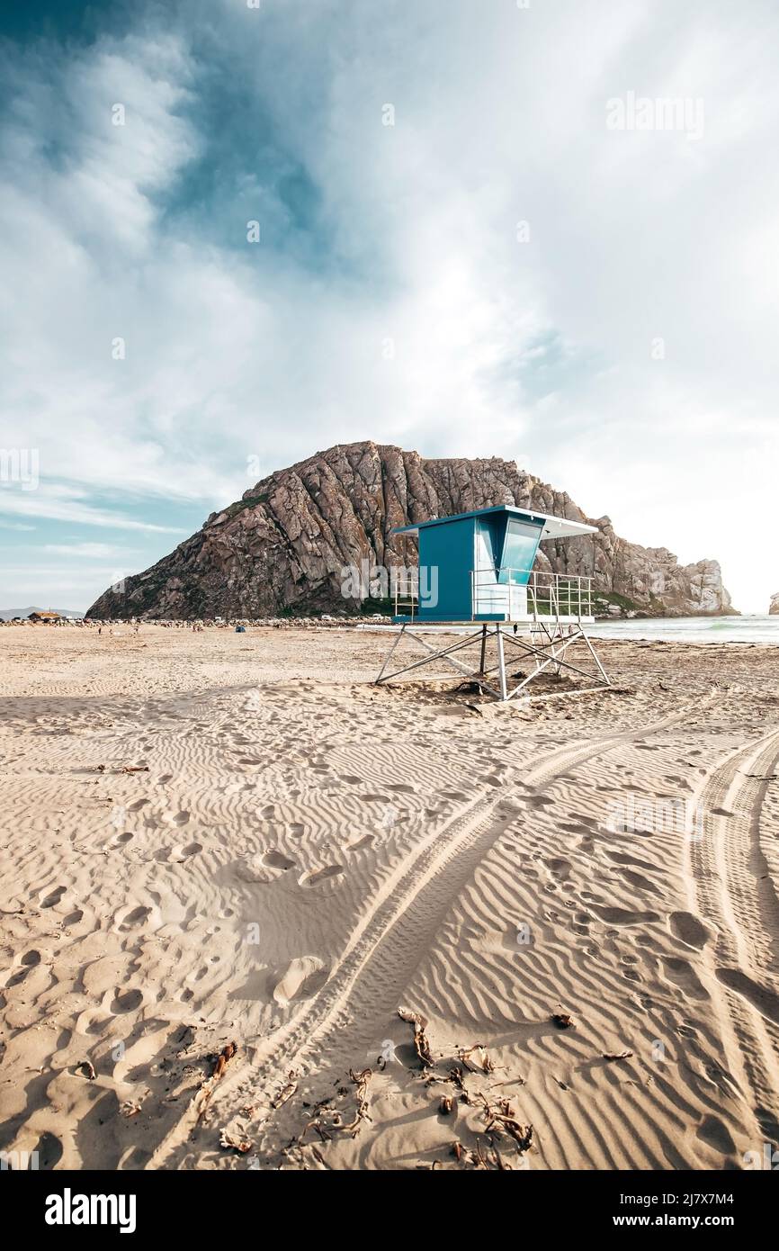 Blue Lifeguard Stand à Morro Beach pendant le coucher du soleil en Californie avec Morro Rock au loin Banque D'Images