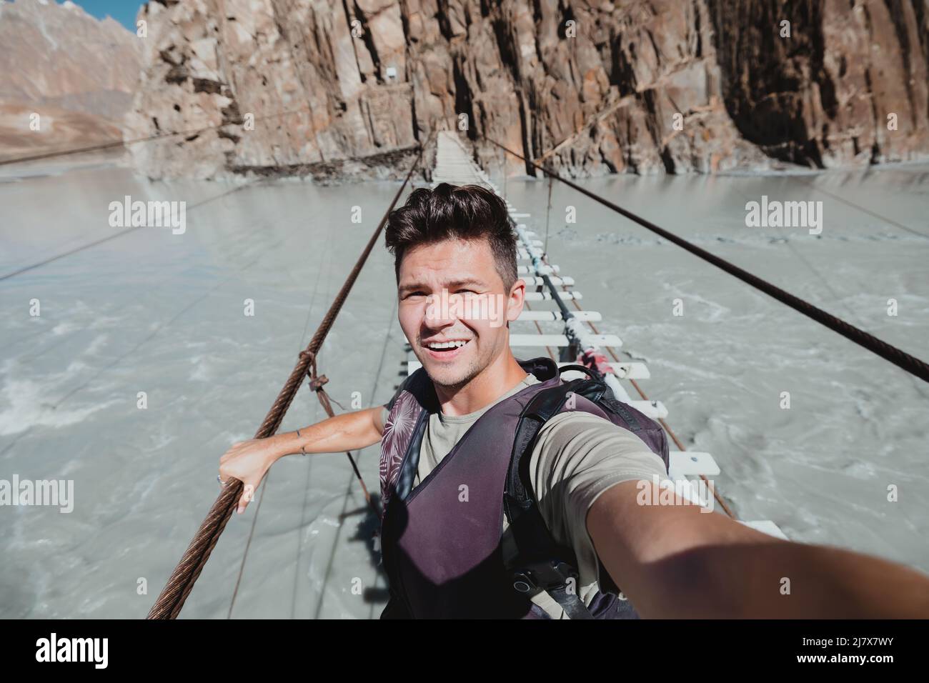 Voyageur sur un dangereux pont suspendu connu sous le nom de Hussani à Hunza Pakistan Banque D'Images