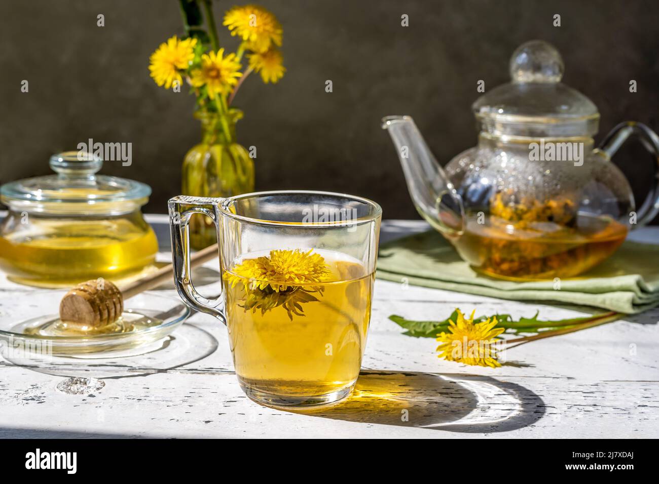 Miel de pissenlit et thé sur la table en bois blanc avec théière, fleurs de pissenlit, mélanger pour le thé Banque D'Images