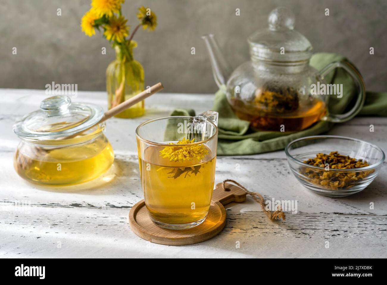 Thé pissenlit et miel sur la table en bois blanc avec théière, fleurs pissenlit, mélange sec pour le thé Banque D'Images