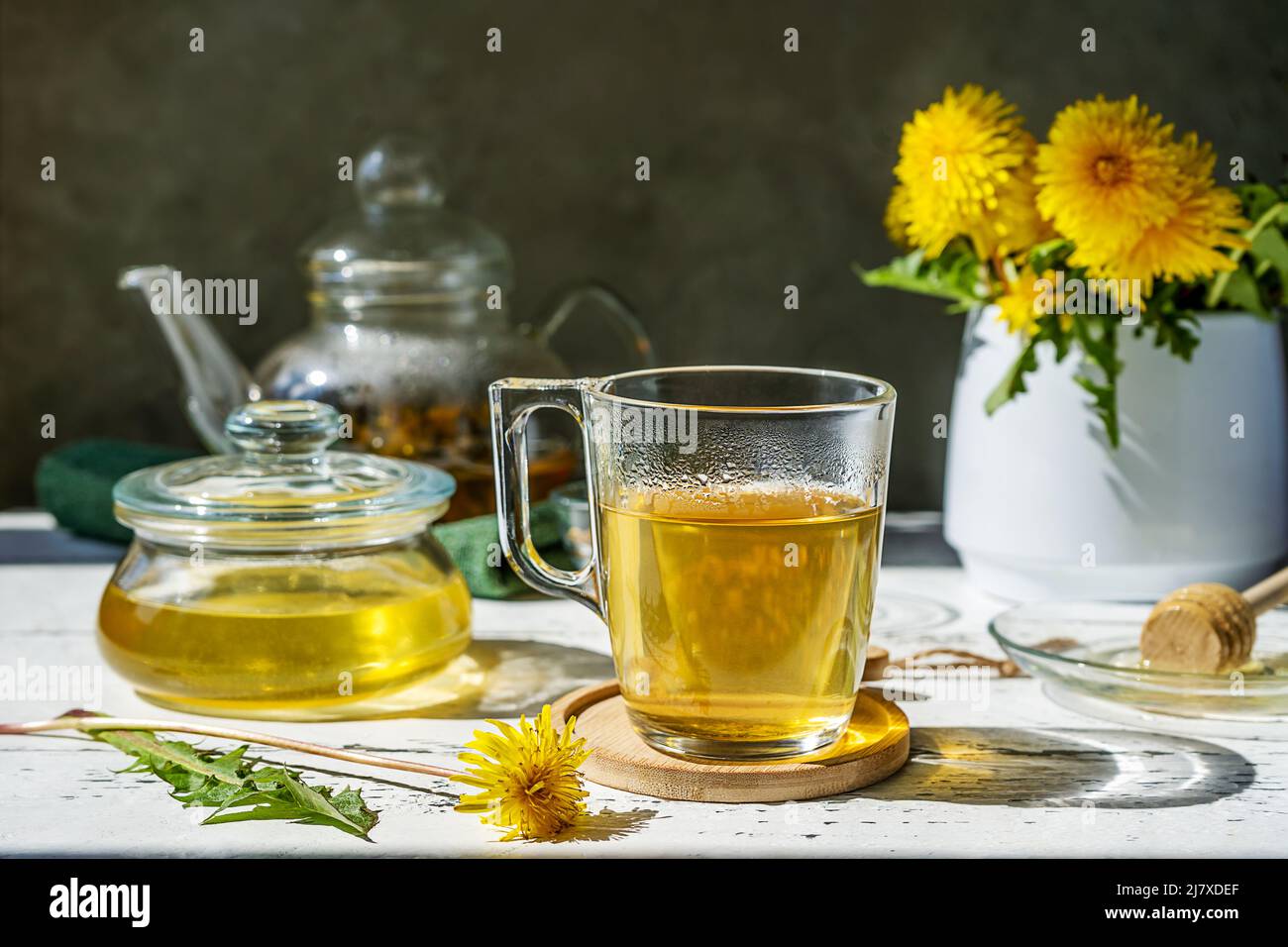 Thé pissenlit et miel sur la table en bois blanc avec théière, fleurs pissenlit, mélange sec pour le thé Banque D'Images