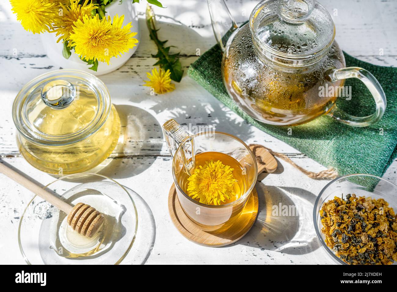 Thé pissenlit et miel sur la table en bois blanc avec théière, fleurs pissenlit, mélange sec pour le thé Banque D'Images