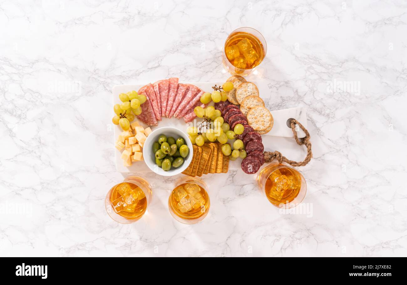 Pose à plat. Scotch sur les rochers en verre à whisky sur une surface en marbre blanc. Banque D'Images