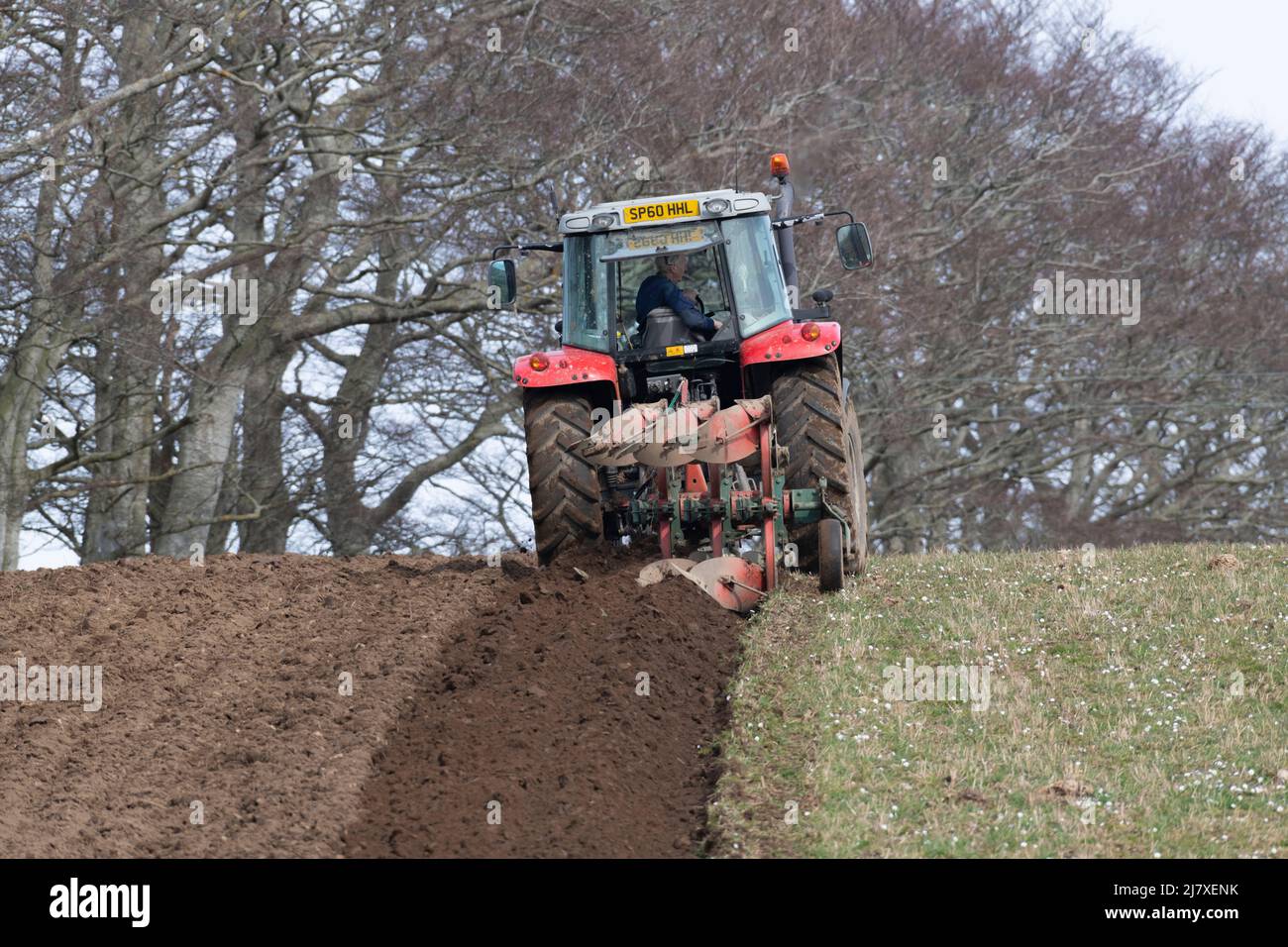 Un fermier labourant un champ Hillside lors d'une journée découverte dans la campagne écossaise Banque D'Images