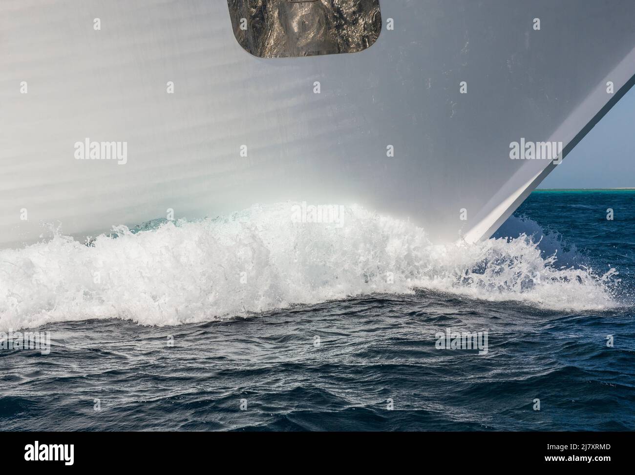 Gros plan de l'arc sur un grand yacht à moteur privé de luxe en route dans la mer tropicale avec la vague d'arc Banque D'Images