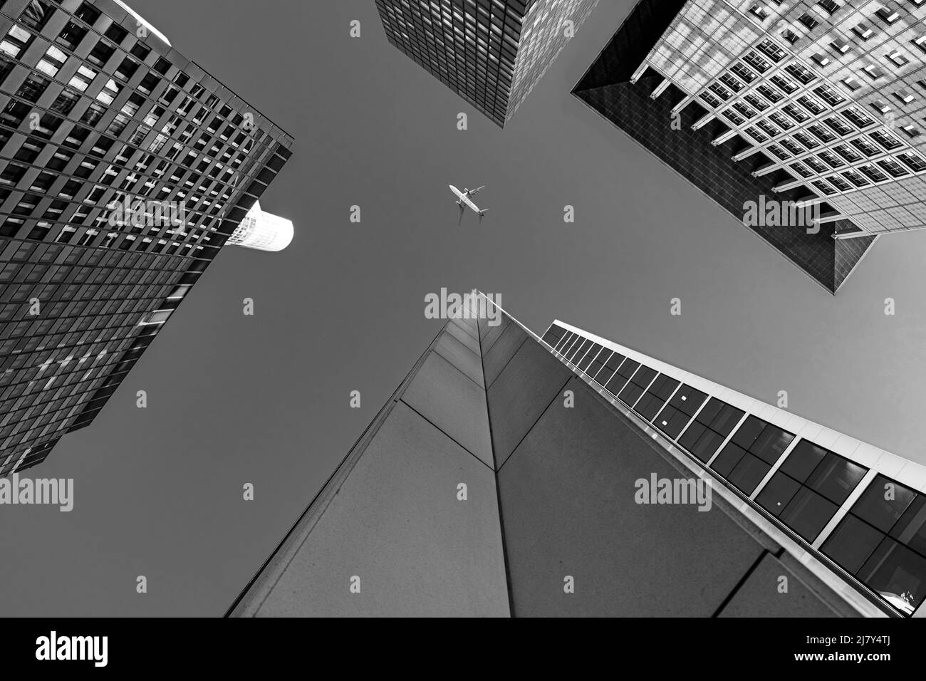 L'avion vole à travers le centre-ville européen dans le style photo monochrome . L'avion survole les gratte-ciel de Francfort. Paysage urbain impressionnant Banque D'Images