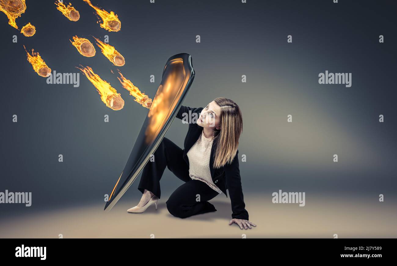 la femme se protège avec un bouclier contre une pluie de roches enflammées Banque D'Images