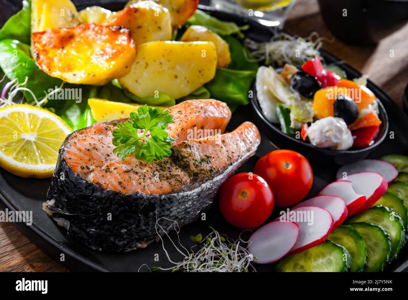 Saumon frit avec pommes de terre et salades de légumes Banque D'Images