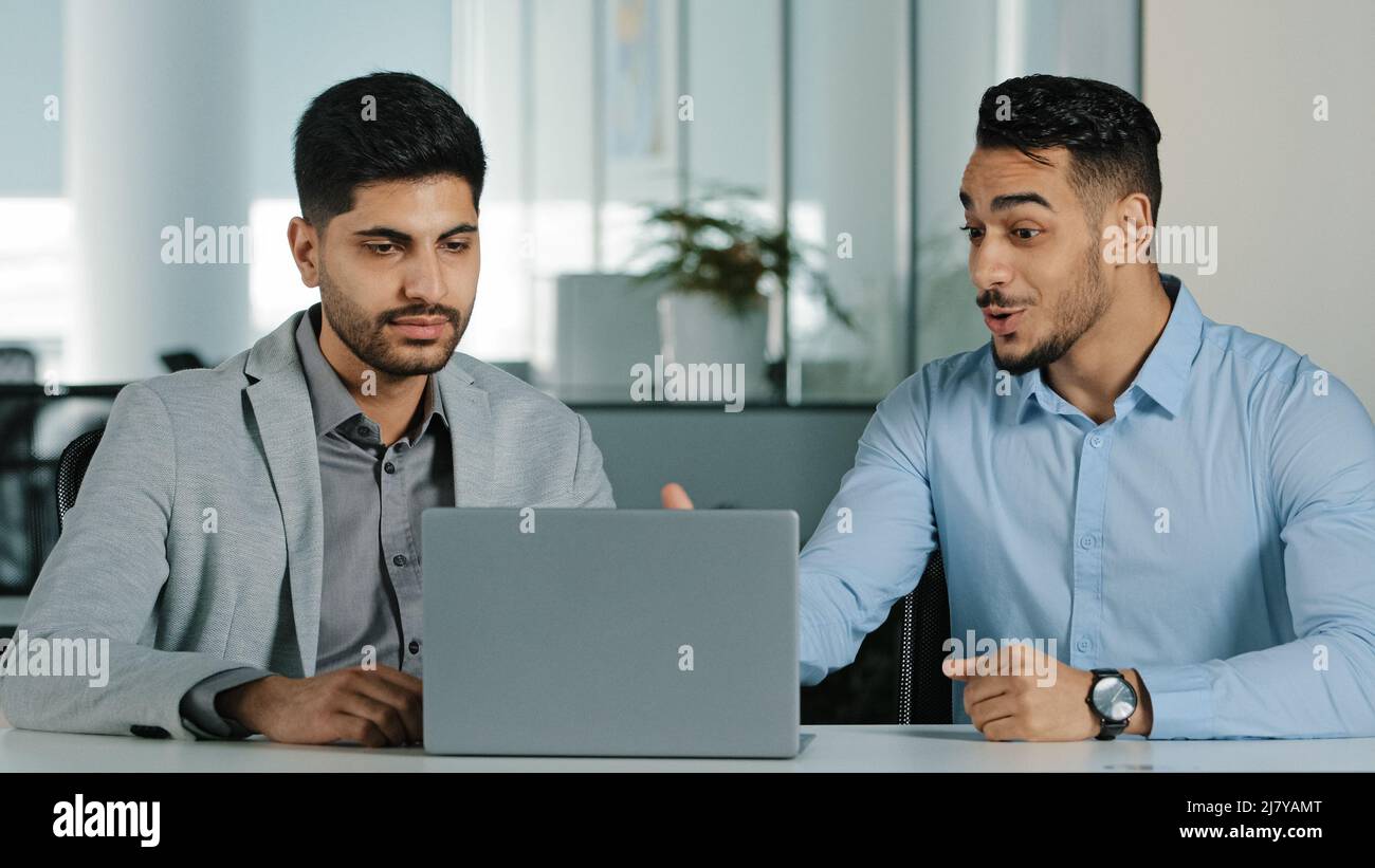 Hommes d'affaires du millénaire orientaux indiens regardant l'écran d'ordinateur portable discutant du projet, satisfaits du résultat des négociations collègues arabes travaillant Banque D'Images