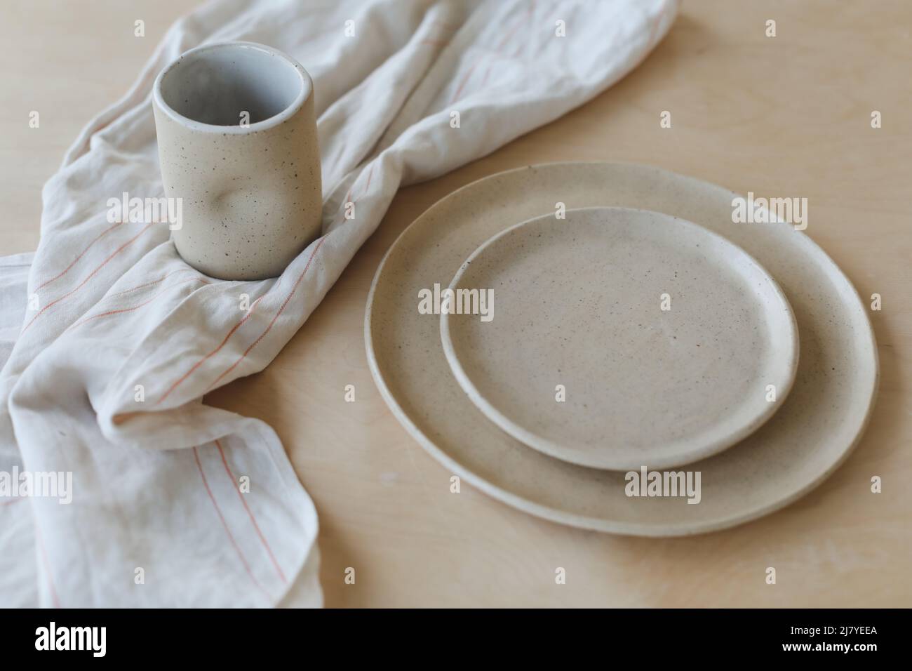 Plaque en céramique beige sur une table en bois. Vaisselle en céramique artisanale minimaliste et poterie Banque D'Images