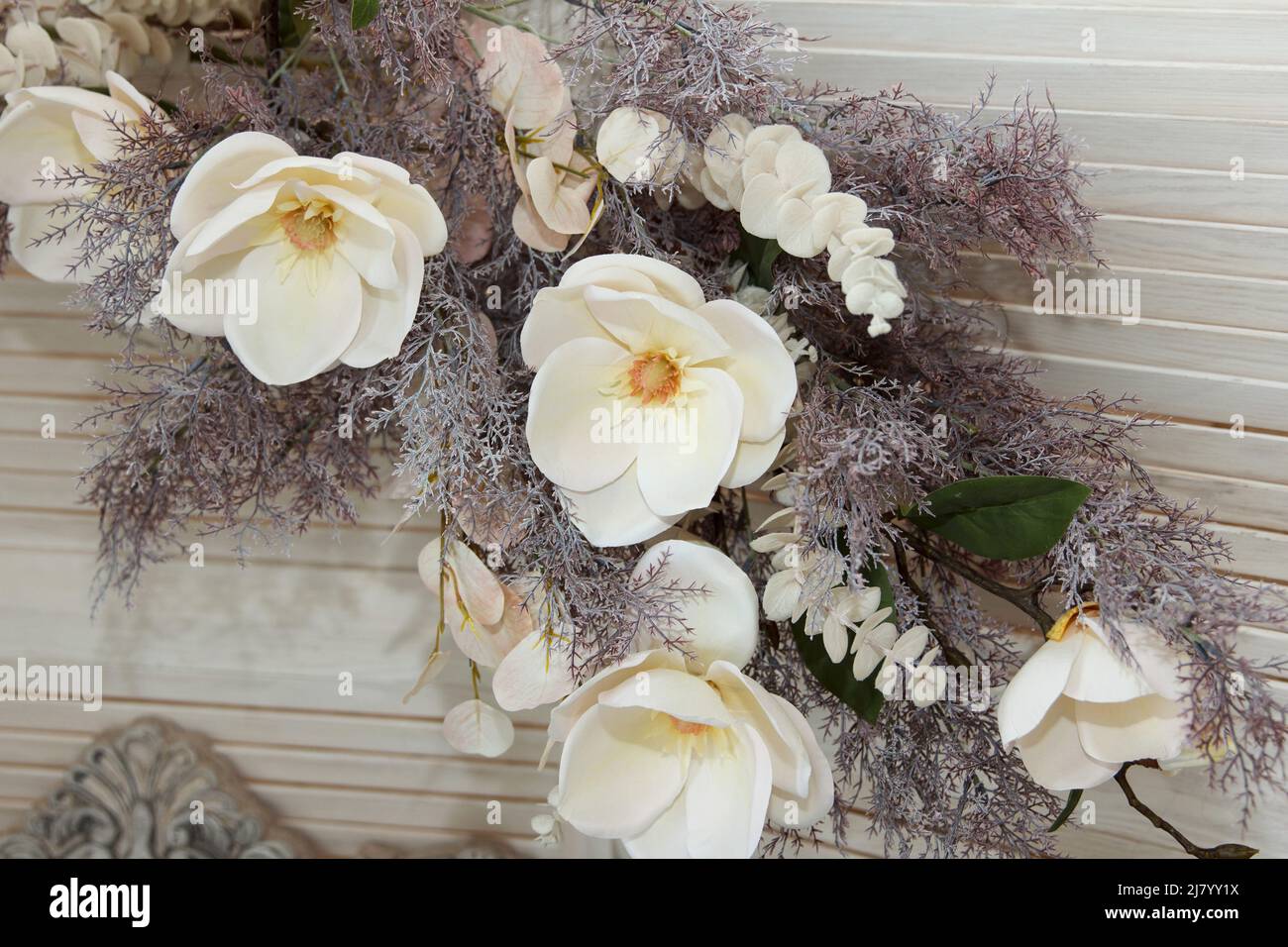 Bouquet de fleurs ornementales blanches en matériau et en plastique accroché sur un mur comme partie de l'intérieur Banque D'Images