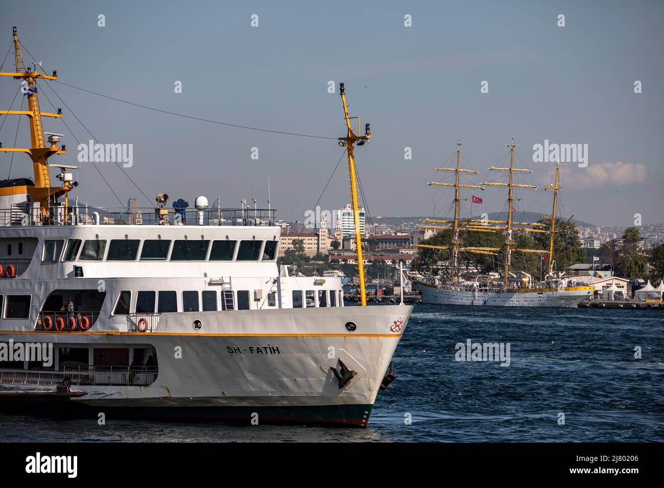 Les lignes de la ville ferry vu à l'embarcadère de Karakoy avec le bateau militaire Nava Scoala Mircea en arrière-plan. Le navire d'entraînement militaire de la marine roumaine, vieux de 84 ans, traverse la mer de Marmara et est ancré à Sarayburu. Banque D'Images