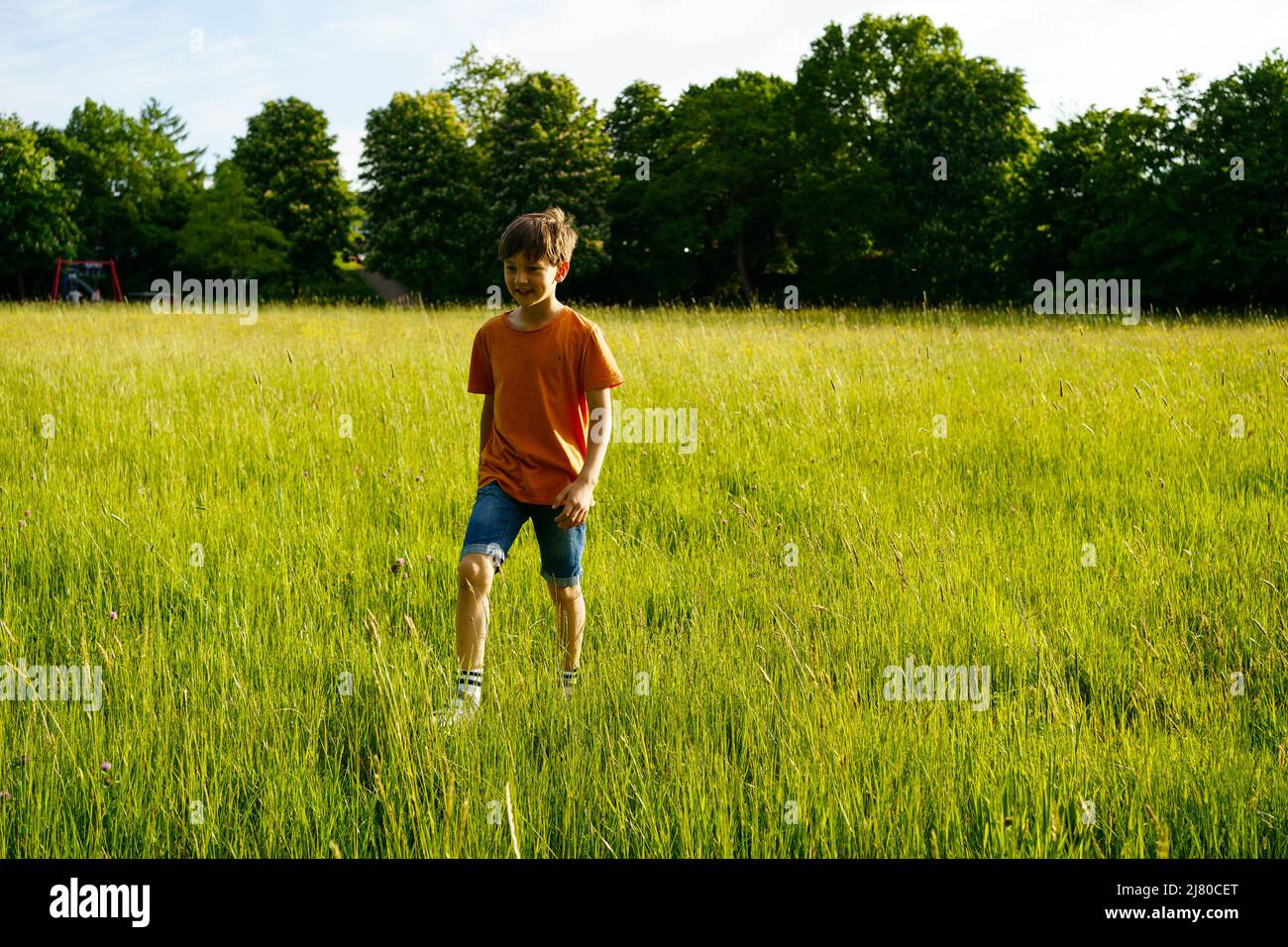 Un garçon court dans un terrain d'été Banque D'Images