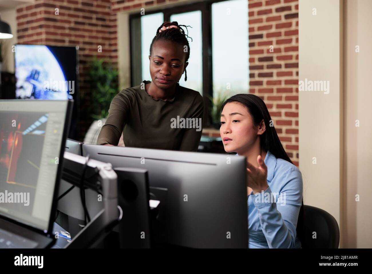 Développeur asiatique et collègue afro-américain développant l'art numérique à l'aide de logiciels de modélisation. Agence de création production bureau travailleurs brainstorming 3D idées de projet. Banque D'Images