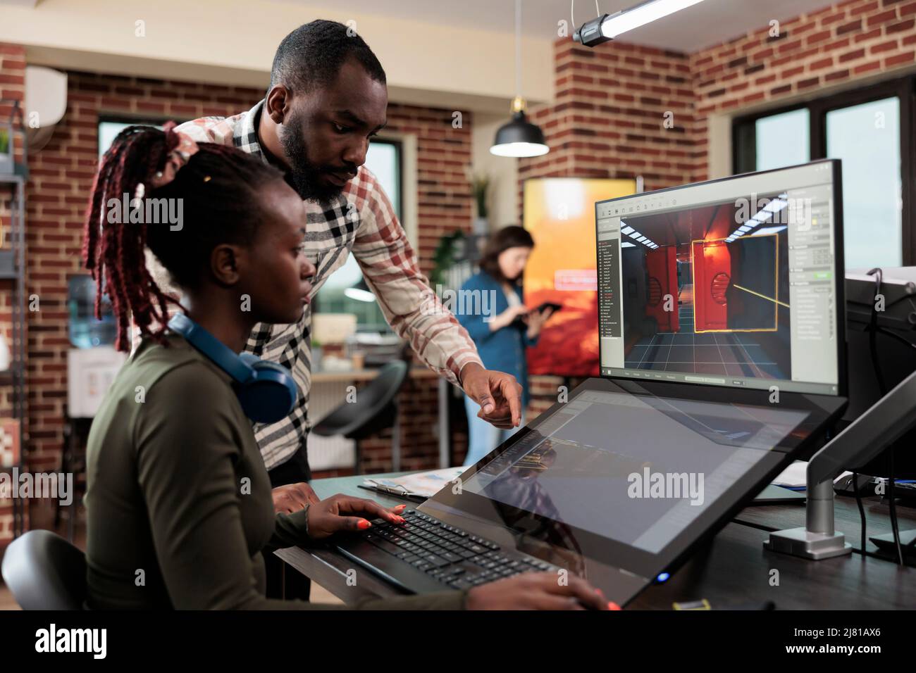 Développement de jeux créatif entreprise employé travaillant sur la conception de niveau de jeu vidéo. Chef d'équipe artistique du département de production 3D avec plusieurs écrans sur le bureau travaillant sur un projet de divertissement numérique. Banque D'Images