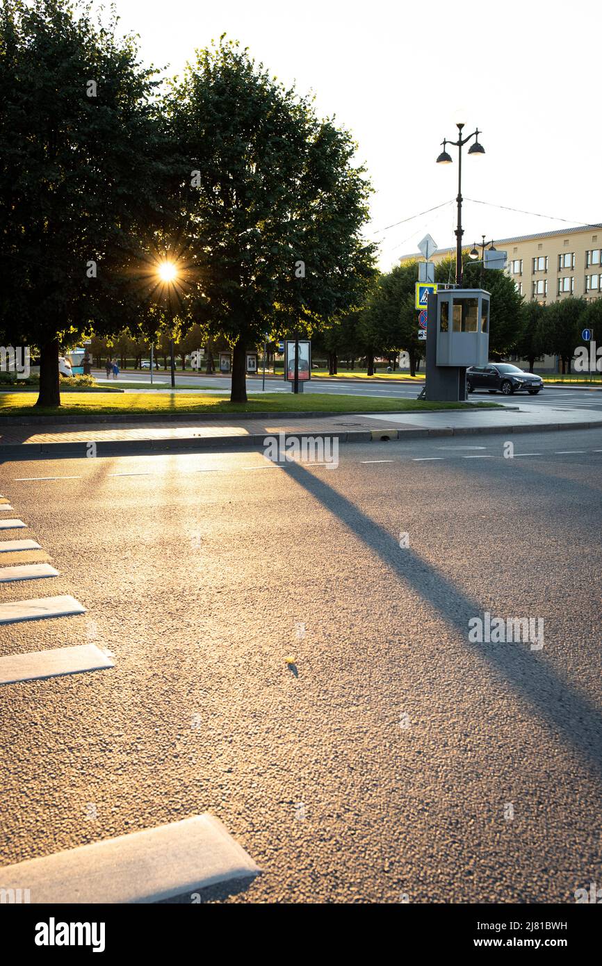 Le soleil couchant brille à travers les arbres de la ville. Vue avant. Banque D'Images